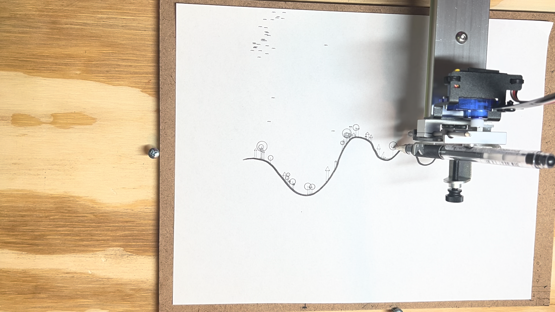 The Axidraw plotting doodles directly onto a participant’s hand-drawn line, with a flock of birds above