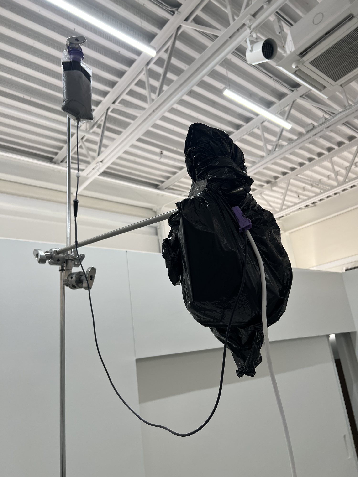 The ink bag at the top of the stand, with the electronics wrapped in a black bag beside it